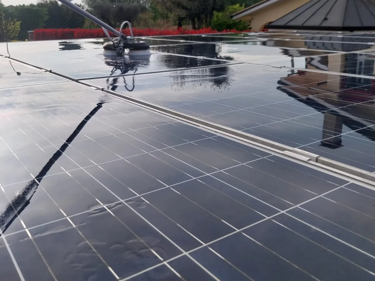 La spazzola che lava un pannello fotovoltaico bagnato